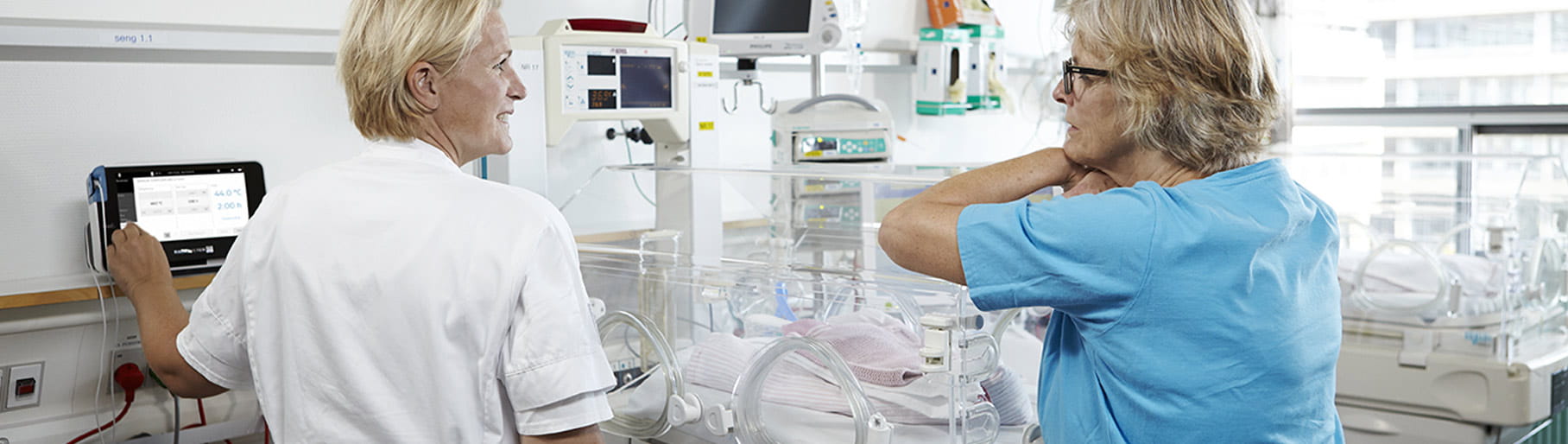 Ситуация в больнице: две медсестры из отделения интенсивной терапии новорожденных используют чрескожный монитор Radiometer